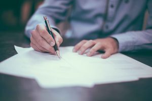 view of a man review a document using a pen to make changes