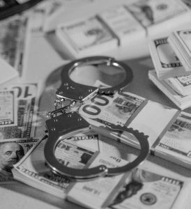 handcuffs on stacks of money