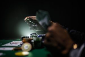 hands holding casino chips on top of cards